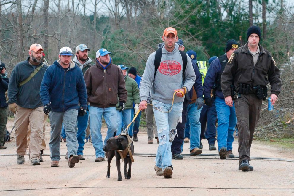 PHOTO: A search and rescue team walk past damage from a tornado in Beauregard, Ala., March 4, 2019.