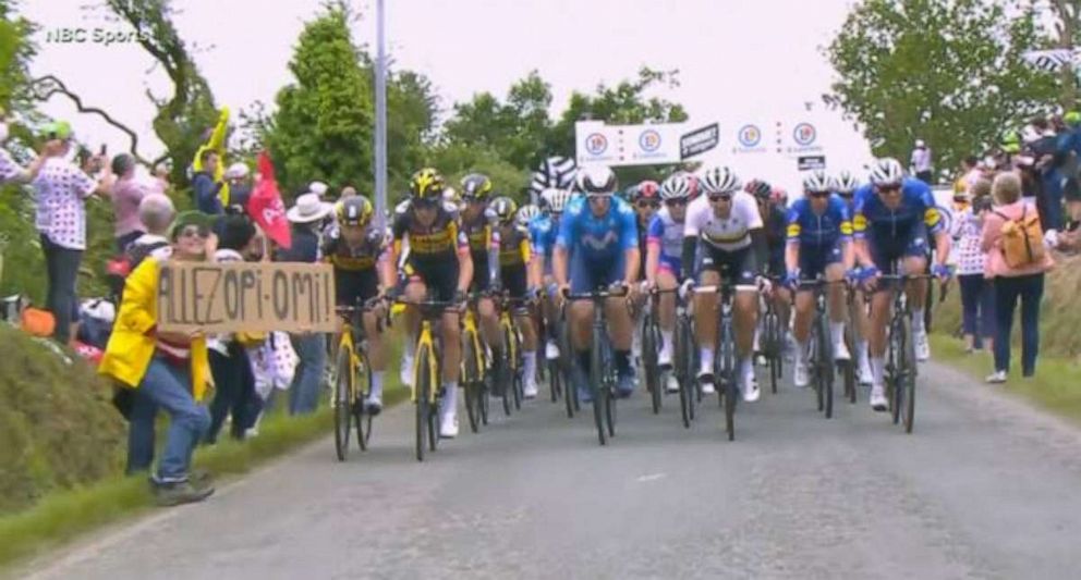 PHOTO: A spectator holding a sign, left, caused a massive crash during the first stage of the Tour de France on Saturday, June 26, 2021.