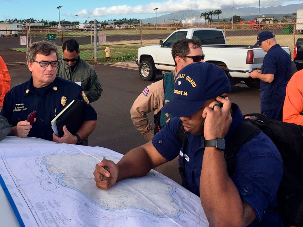 PHOTO: Coast Guard Incident Command Post responders look over a map of the Na Pali Coast State Wilderness Park on the Hawaiian island of Kauai on Friday, Dec. 27, 2019, the day after a tour helicopter disappeared with seven people aboard.