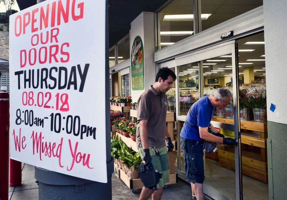 PHOTO: Workers do some last minute repairs on an entrance door to a Trader Joe's market in the Silver Lake district of Los Angeles, Aug. 2, 2018, before reopening.