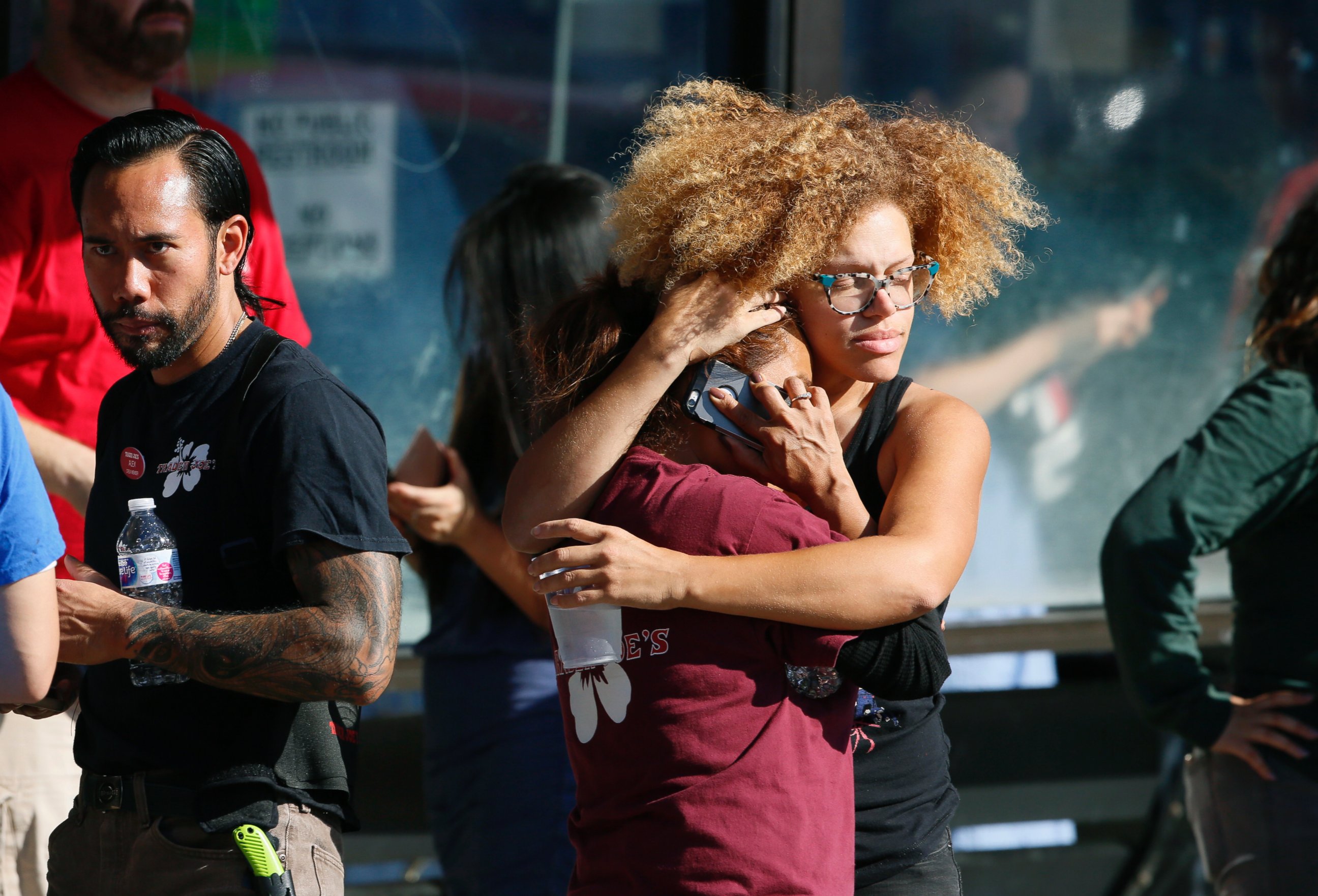 Unidentified Trader Joe's supermarket employees hug after being evacuated by Los Angeles Police after a gunman barricaded himself inside the store in Los Angeles, July 21, 2018.