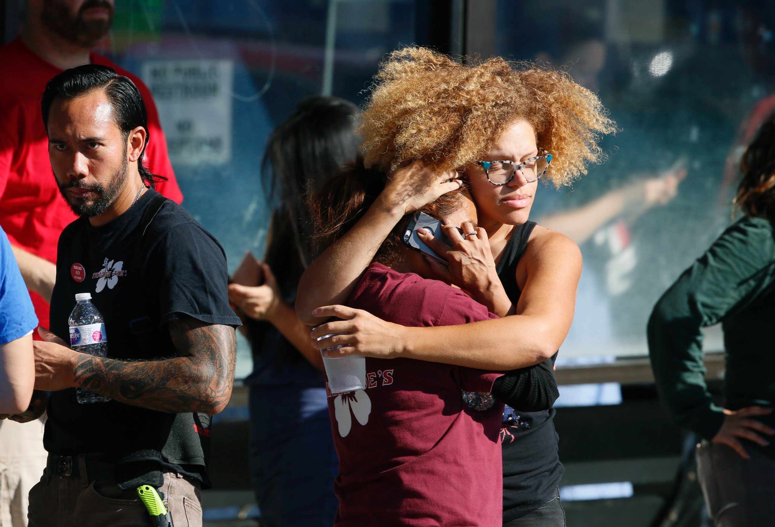 Unidentified Trader Joe's supermarket employees hug after being evacuated by Los Angeles Police after a gunman barricaded himself inside the store in Los Angeles Saturday, July 21, 2018.