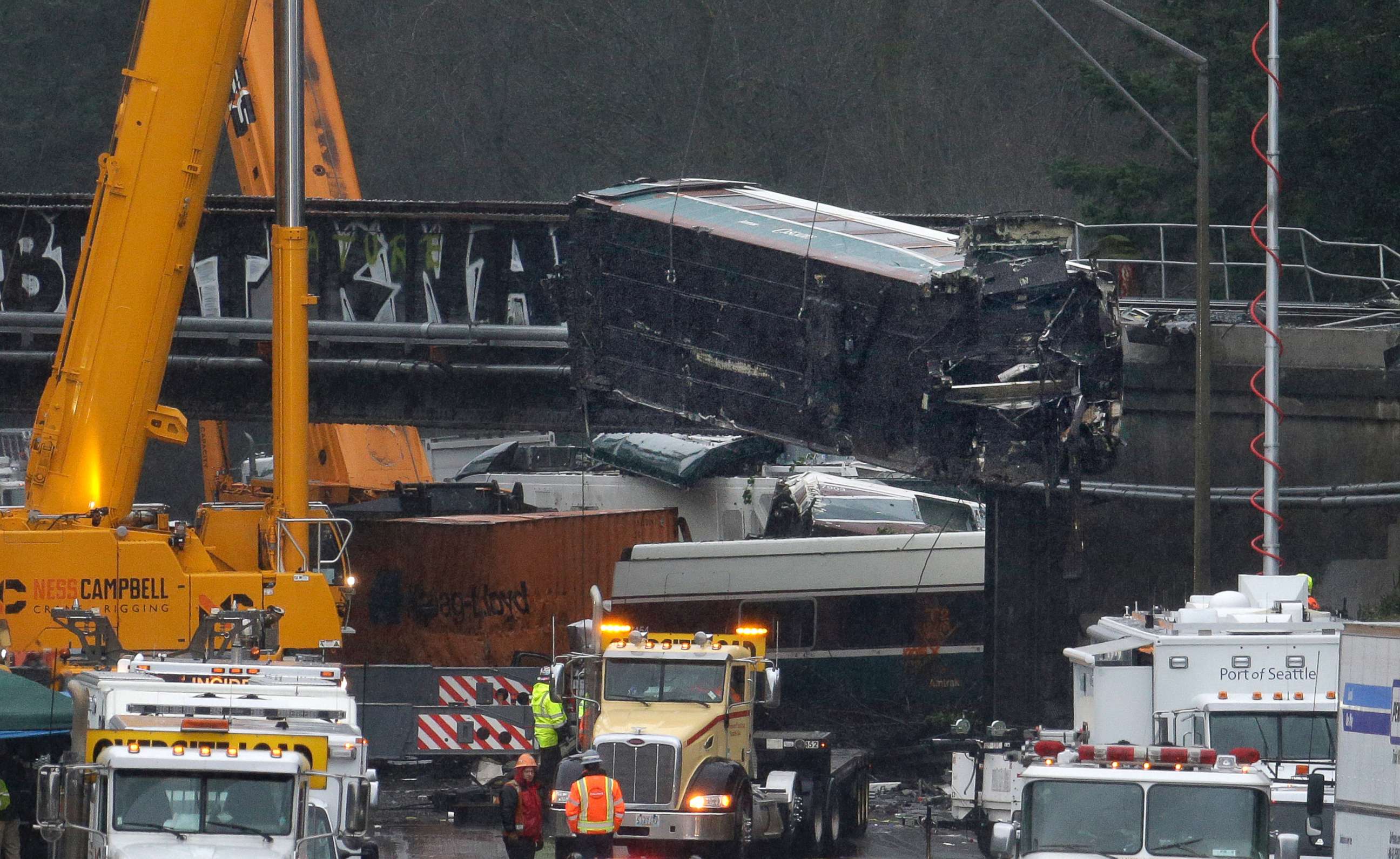 PHOTO: A damaged Amtrak train car is lowered from an overpass at the scene of Monday's deadly train crash onto Interstate 5, Dec. 19, 2017, in DuPont, Wash. 