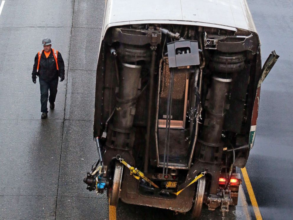 PHOTO: A worker walks along a damaged train car atop a flat bed trailer taken from the scene of Mondays deadly Amtrak train crash onto Interstate 5, Dec. 19, 2017, in DuPont, Wash.