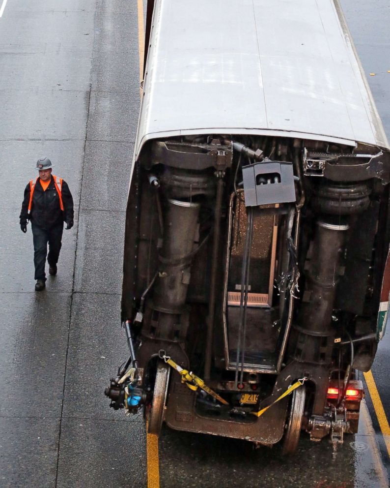 PHOTO: A worker walks along a damaged train car atop a flat bed trailer taken from the scene of Monday's deadly Amtrak train crash onto Interstate 5, Dec. 19, 2017, in DuPont, Wash.