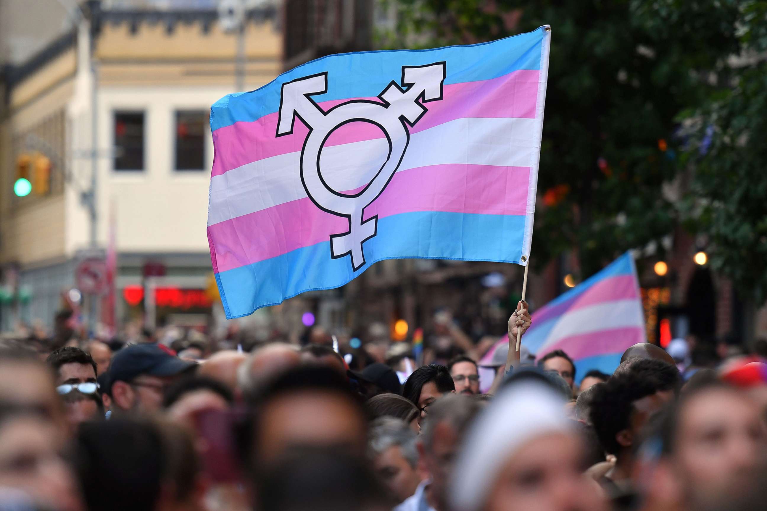 PHOTO: A person holds a transgender pride flag as people gather on Christopher Street outside the Stonewall Inn for a rally to mark the 50th anniversary of the Stonewall Riots in New York, June 28, 2019. 