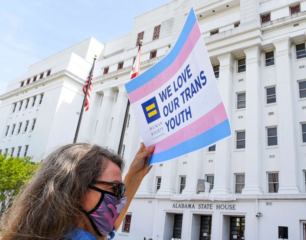 PHOTO: Jodi Womack holds a sign that reads "We Love Our Trans Youth" during a rally at the Alabama State House to draw attention to anti-transgender legislation introduced in Alabama, March 30, 2021, in Montgomery, Alabama.