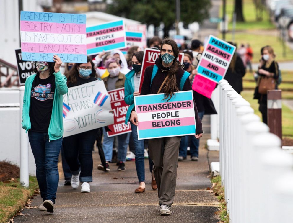 PHOTO: Protesters march with signs in support of transgender and transgender youth rights march around the Alabama State House in Montgomery, Ala., March 2, 2021.