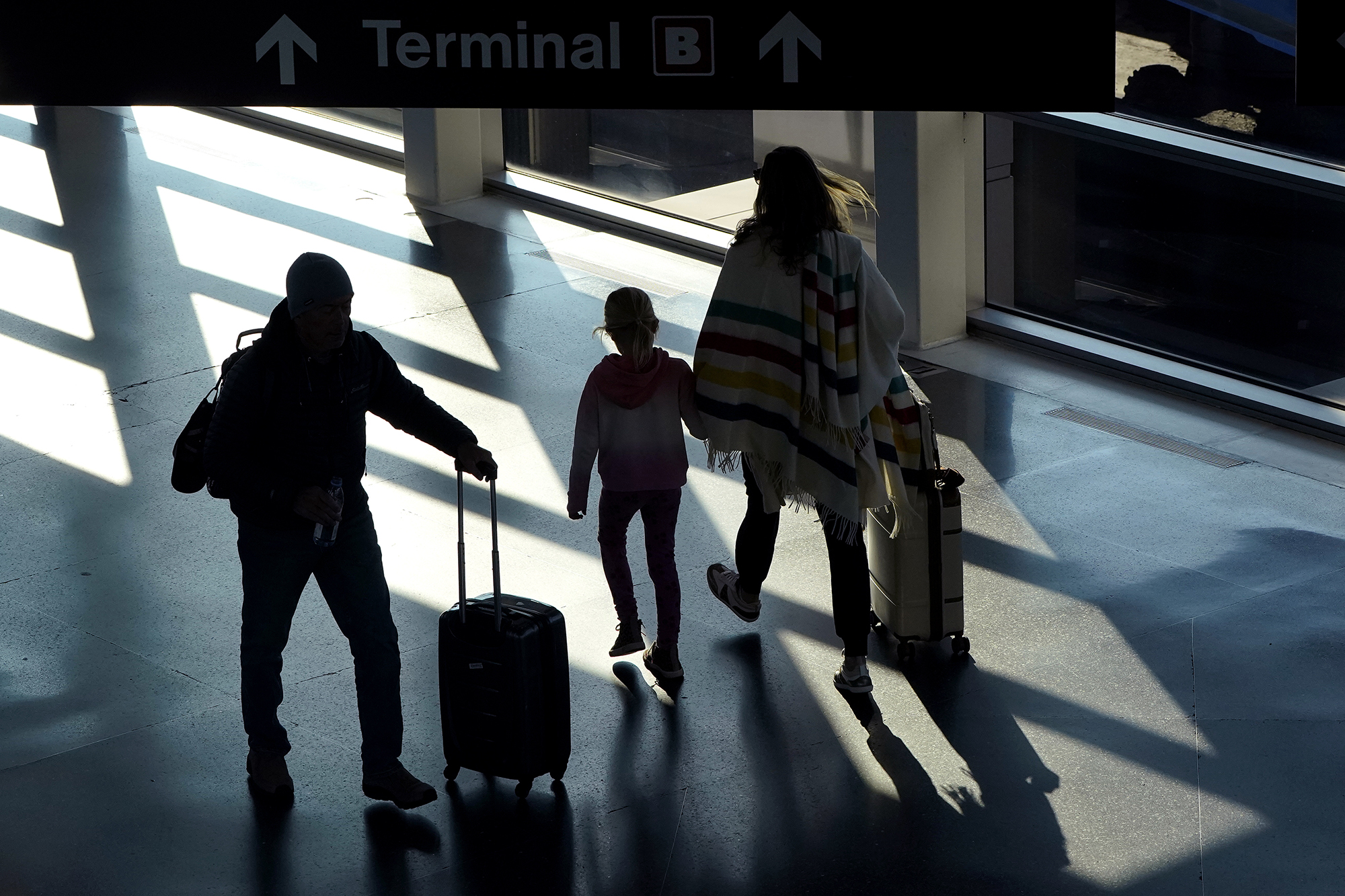 PHOTO: Travelers pull their luggage while walking between terminals the day before Thanksgiving at Logan International Airport in Boston, Nov. 23, 2022.