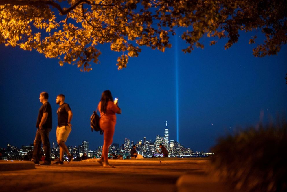 PHOTO: People watch the Tribute in Light art installation and the One World Trade Center on the day marking the 20th anniversary of the Sept. 11, 2001, attacks in New York City, as it is seen from Weehawken, N.J., Sept. 11, 2021. REUTERS/Eduardo Munoz