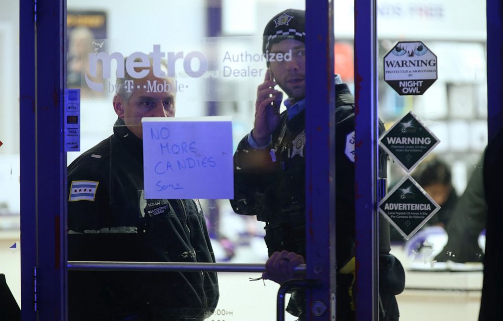 PHOTO: A police supervisor and officer stand inside a cellphone store in the 3700 block of West 26th Street in Chicago, where a 7-year-old girl who was shot while trick-or-treating was brought inside until transported, on Thursday, Oct. 31, 2019.