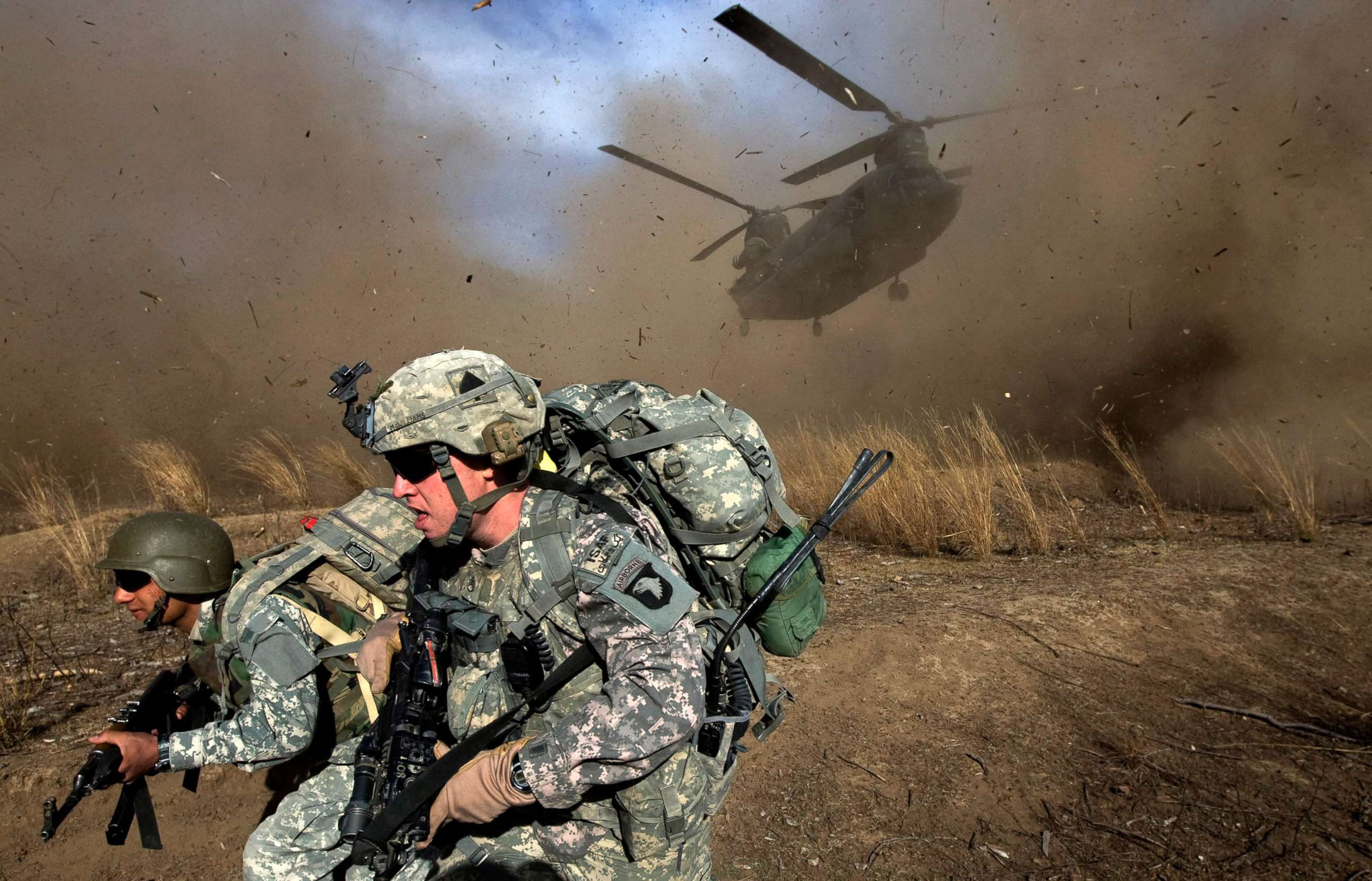 PHOTO: U.S Army soldiers and Afghan National Army soldiers run hear a Chinook helicopter landing in hostile territory during Operation Radu Bark VI in the Spira mountains in Khost province, near the Afghan-Pakistan Border, Nov. 11, 2009.  