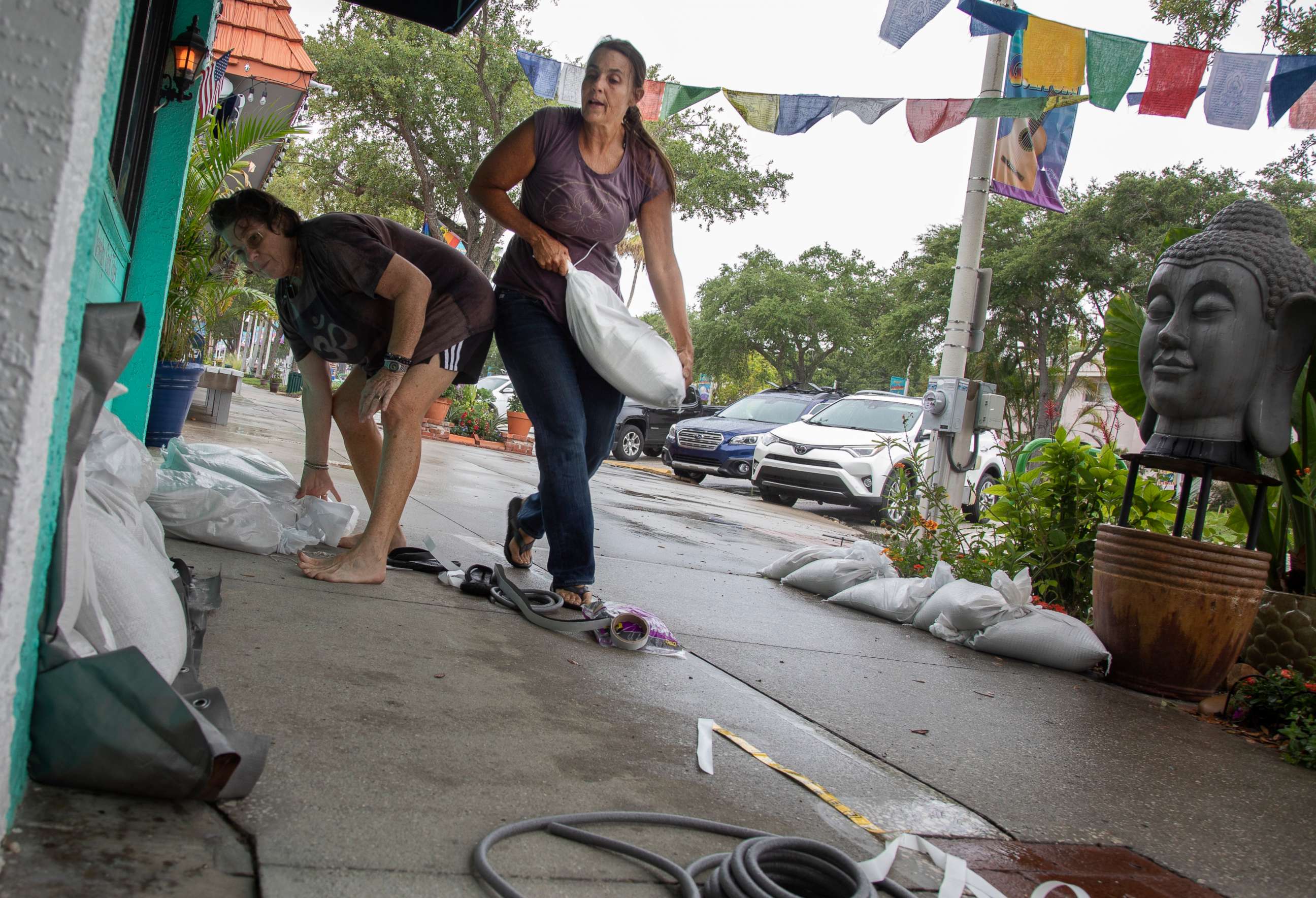 PHOTO: Melissa Loven and Crea Egan place sandbags in front of a store ahead of tropical storm Elsa, July 6, 2021, in Tampa, Fla.