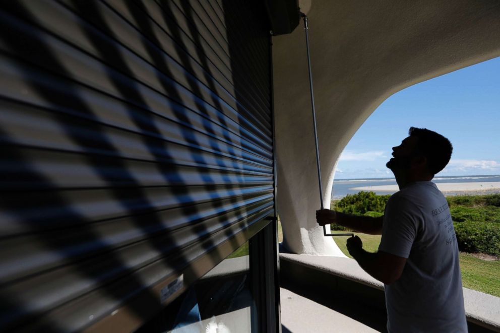 PHOTO: Chris Brace, from Charleston, S.C. lowers hurricane shutters on a client's house in preparation for Hurricane Florence at Sullivan's Island, S.C., Sept. 10, 2018.