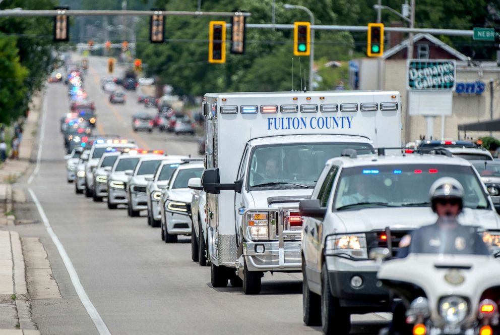 PHOTO: A long line of emergency vehicles, including an ambulance carrying the remains of Fulton County Sheriff's Deputy Troy Chisum, heads to a Lewistown funeral home on June 26, 2019 in Peoria.