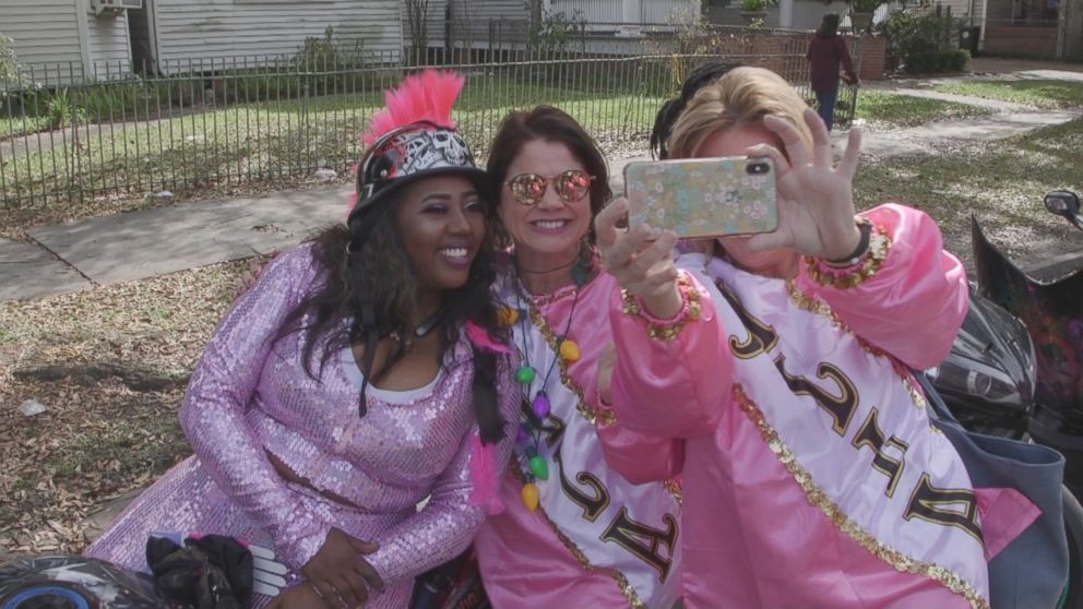 Mardi Gras festival goers pose with Tru, one of the founding members of "The Caramel Curves," during the parade.