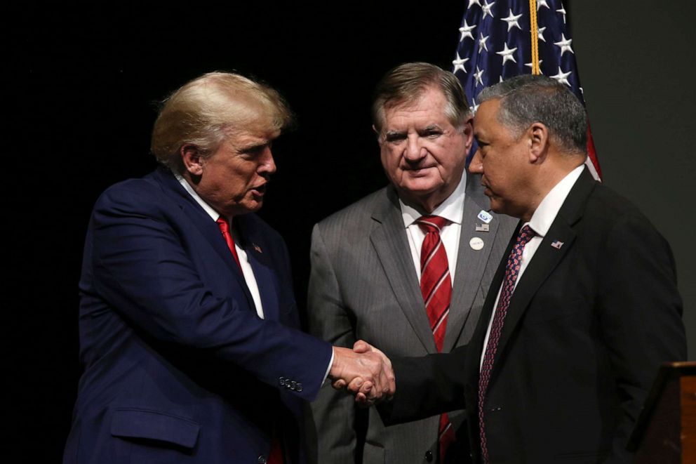 PHOTO: Newly announced Chairman of the N.H. GOP Chris Ager, right, shakes hands with former President Donald Trump as outgoing N.H. GOP Chairman Stephen Stepanek looks on, on Jan. 28, 2023, in Salem, N.H.
