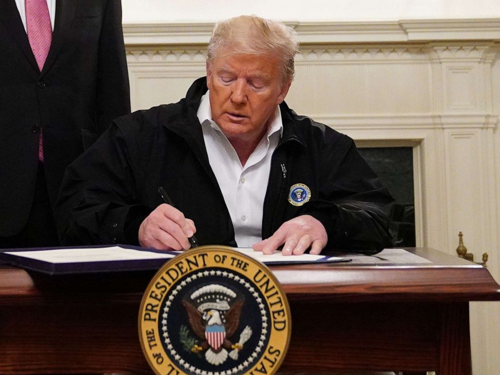 PHOTO: President Donald Trump signs a eight billion USD emergency funding bill to combat COVID-19 in the Diplomatic Room of the White House, in Washington on March 6, 2020.