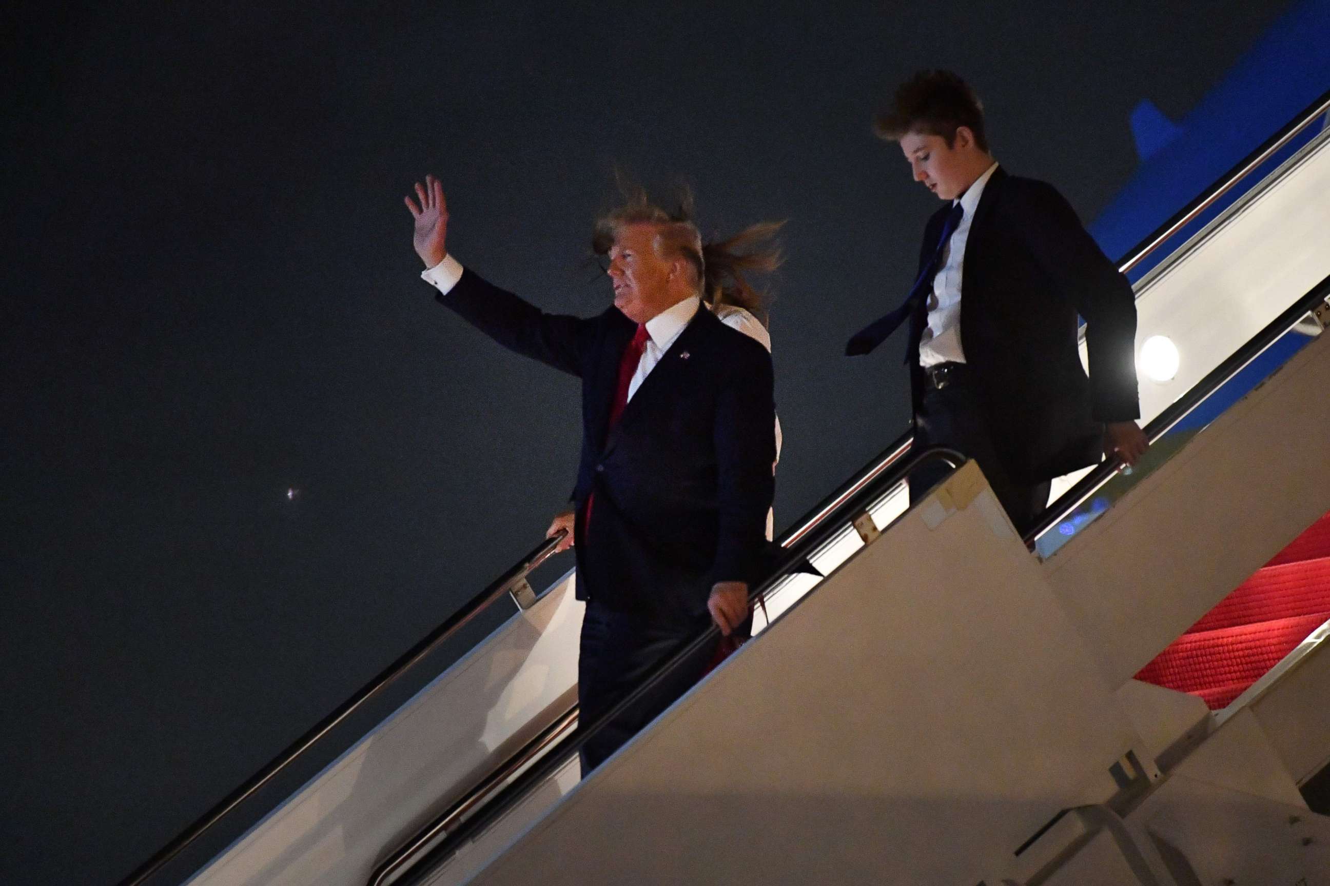 PHOTO: US President Donald Trump waves as he US First Lady Melania Trump and son Barron Trump arrive at Palm Beach International Airport in West Palm Beach on December 20, 2019. 