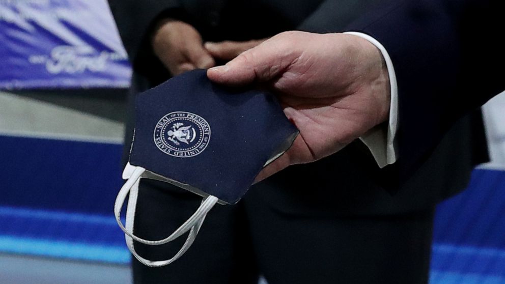 PHOTO: President Donald Trump holds a protective face mask with a presidential seal on it that he said he had been wearing earlier in his tour at the Ford Rawsonville Components Plant in Ypsilanti, Mich., May 21, 2020.
