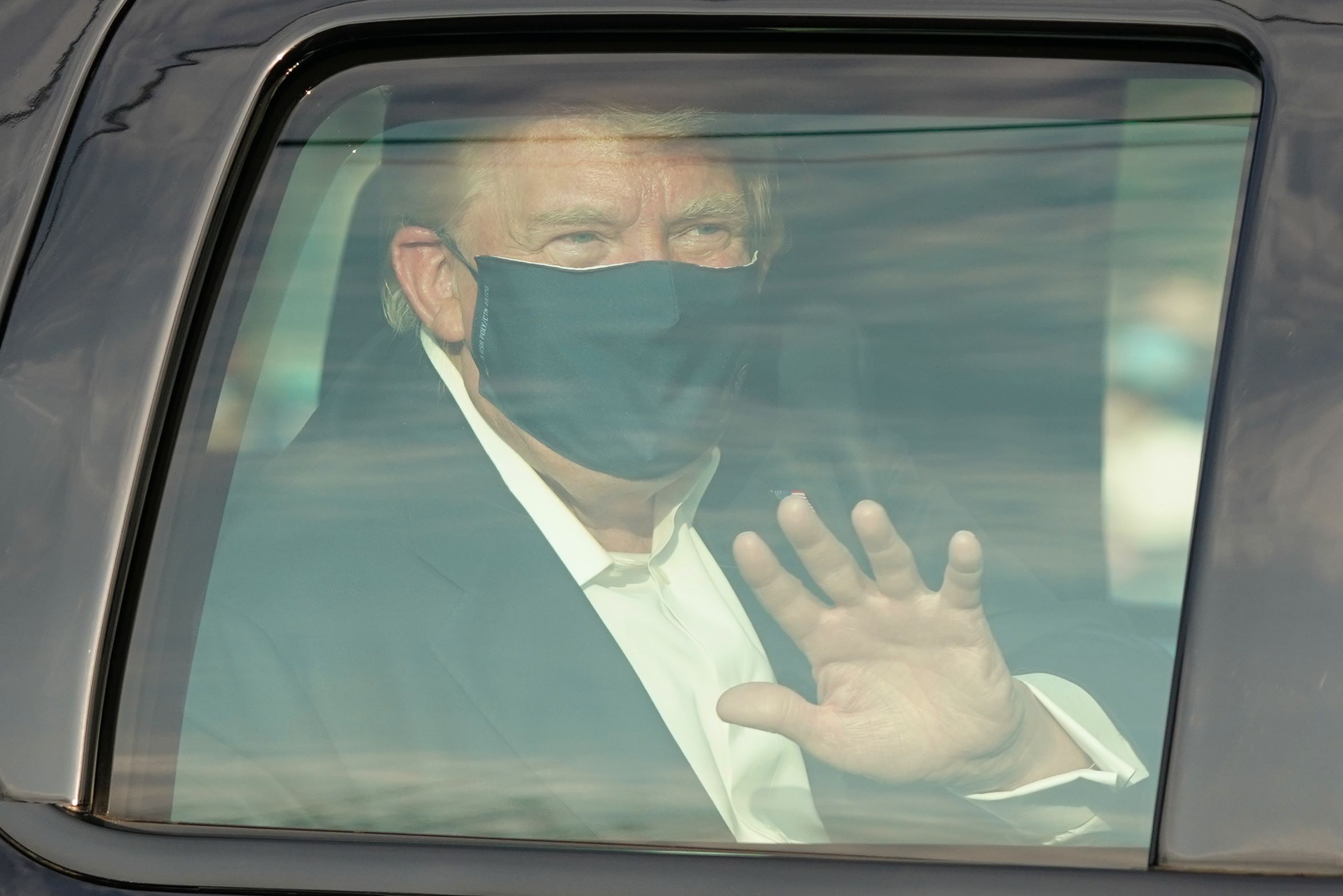 PHOTO: A car with US President Trump drives past supporters in a motorcade outside of Walter Reed Medical Center in Bethesda, Maryland on October 4, 2020. 