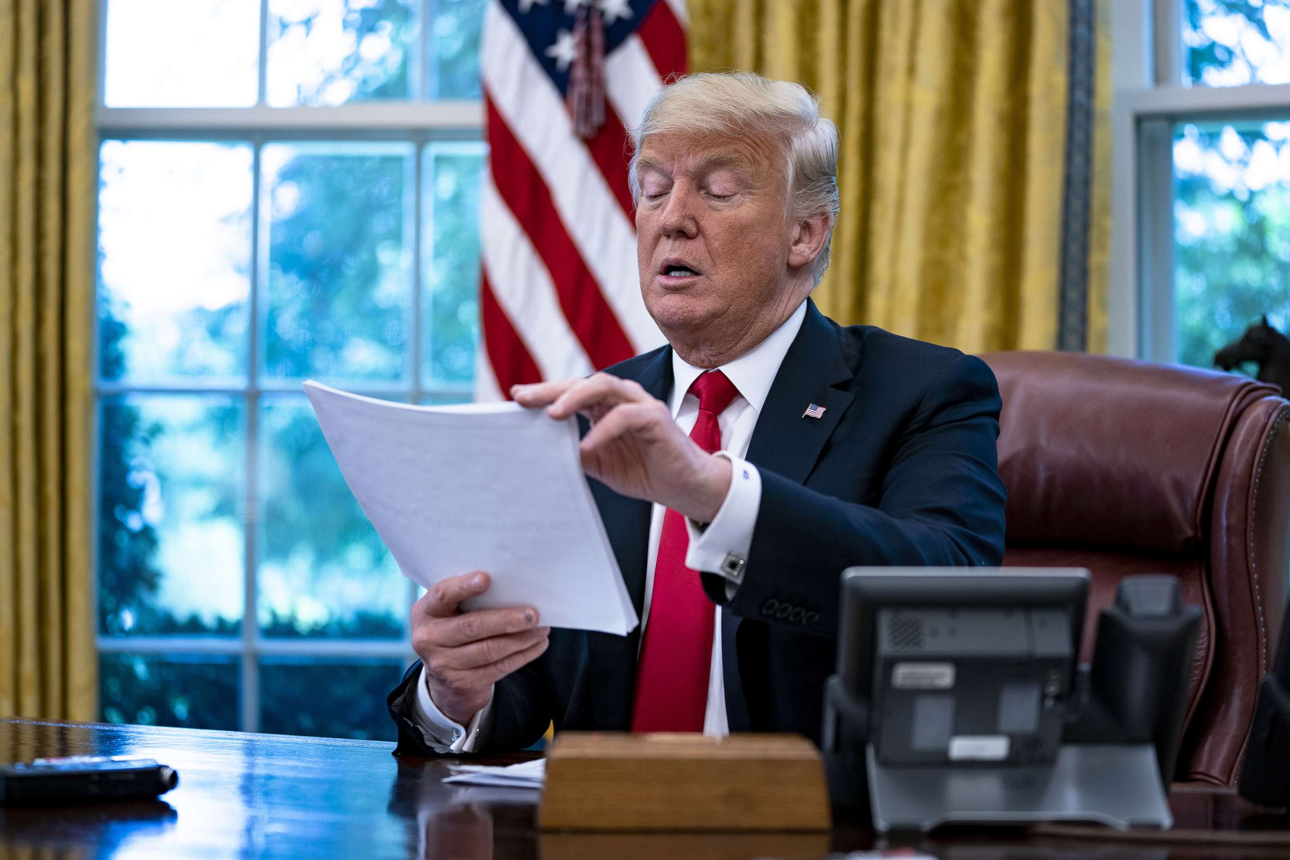 PHOTO: In this Aug. 30, 2018, file photo, President Donald Trump reviews papers during an interview in the Oval Office of the White House in Washington, D.C.