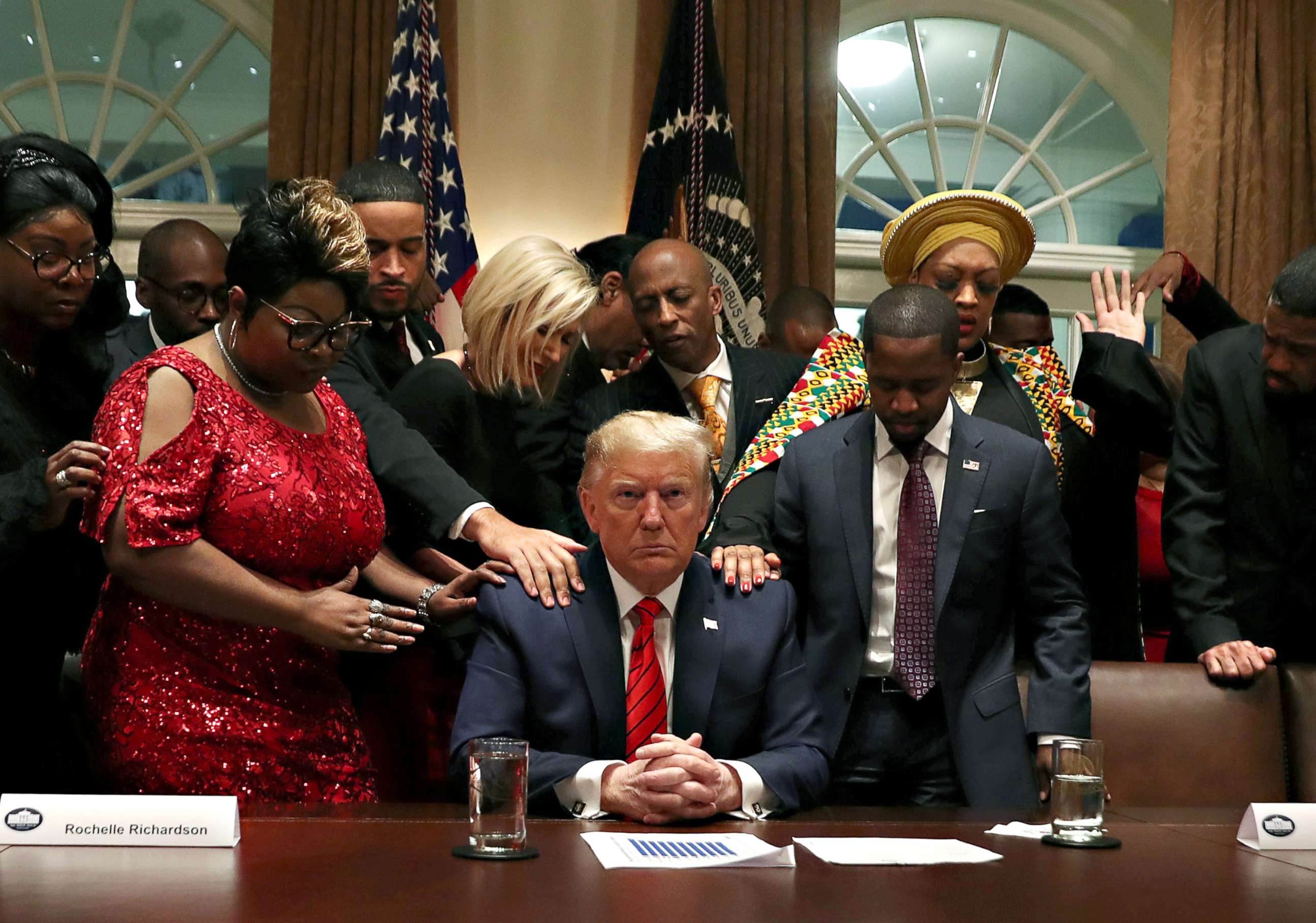 PHOTO: African-American supporters, including Terrence Williams, Angela Stanton and Diamond and Silk, pray with President Donald Trump in the Cabinet Room of the White House, in Washington on Feb. 27, 2020.