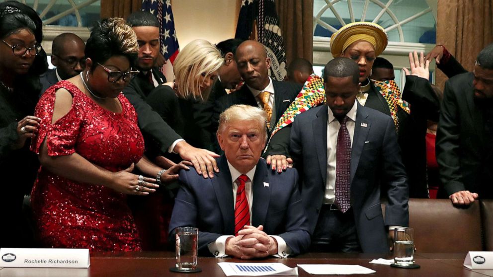 PHOTO: African-American supporters, including Terrence Williams, Angela Stanton and Diamond and Silk, pray with President Donald Trump in the Cabinet Room of the White House, in Washington on Feb. 27, 2020.