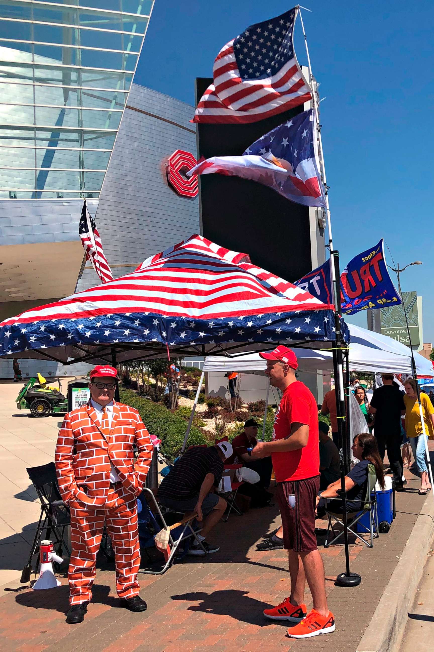 PHOTO: Supporters of President Trump, including a man dressed as the border wall, line up outside outside an arena in Tulsa, Okla., June 18, 2020, where the president will hold his first campaign rally in months on June 20.
