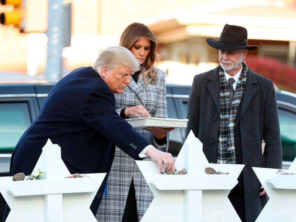 PHOTO: President Donald Trump and first lady Melania Trump put down stones from the White House at a memorial outside for those killed at the Pittsburghs Tree of Life Synagogue in Pittsburgh, Oct. 30, 2018, as Tree of Life Rabbi Jeffrey Myers watches.