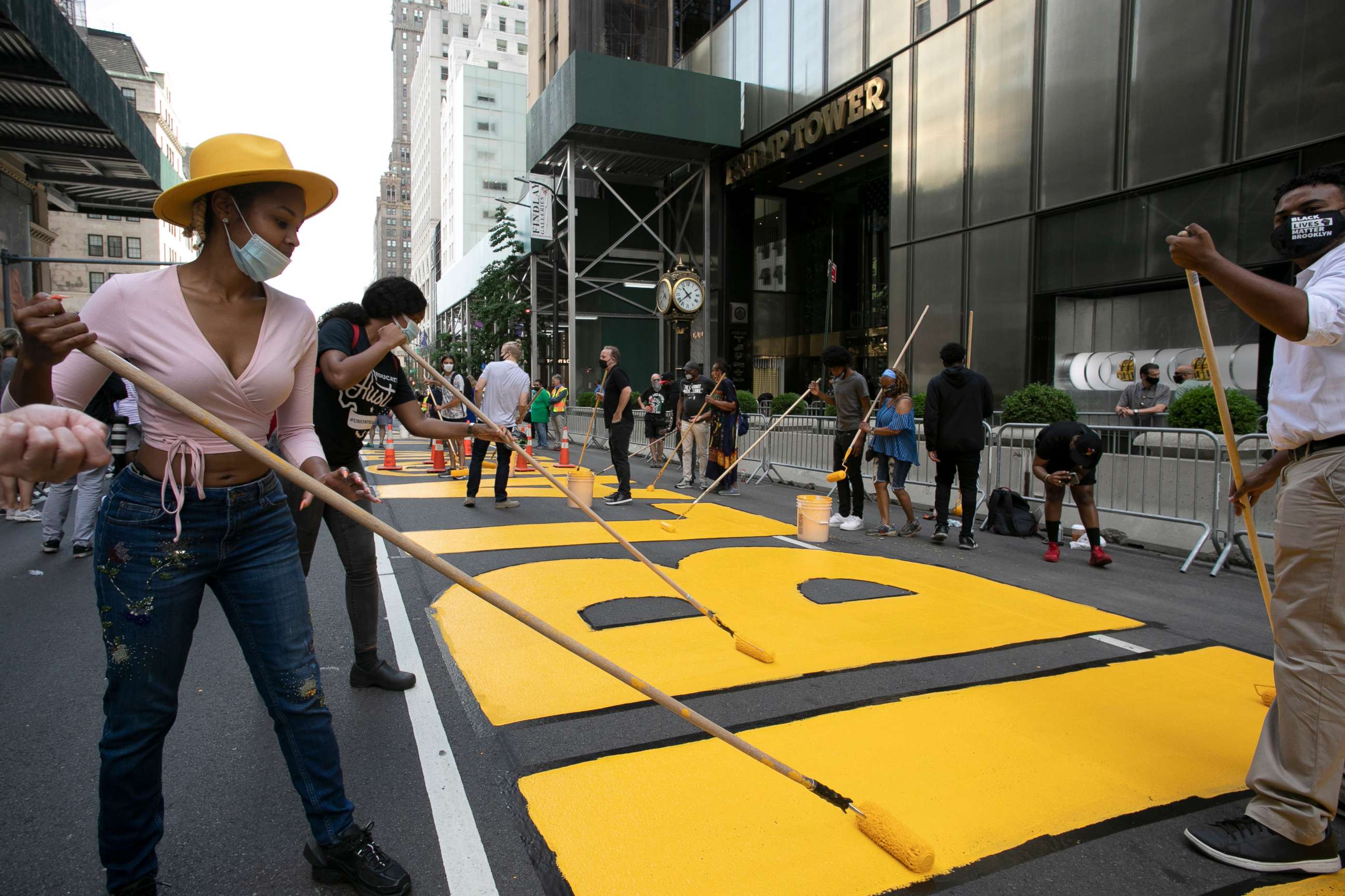 PHOTO: Azia Toussaint, left, participates in the painting of Black Lives Matter on Fifth Avenue in front of Trump Tower, July 9, 2020, in New York.