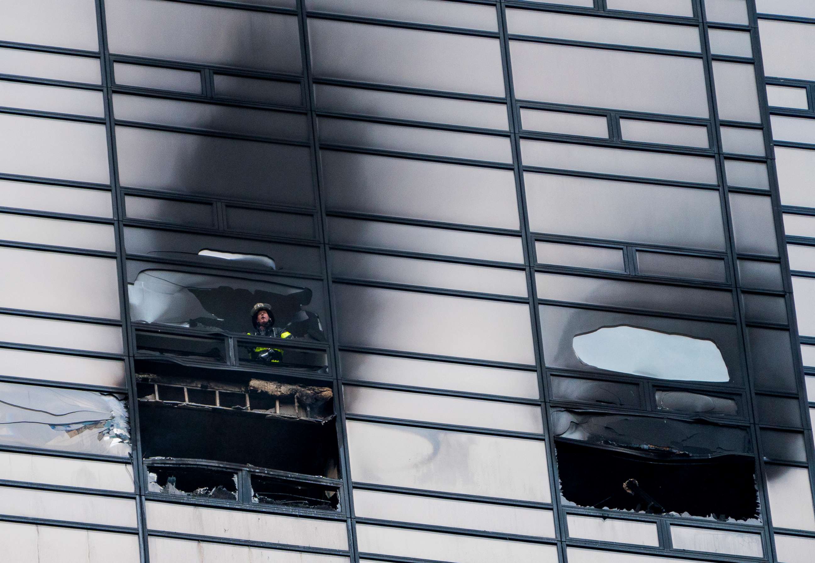 PHOTO: A firefighter looks out from the window of a damaged apartment in Trump Tower in New York, April 7, 2018. The New York Fire Department says the blaze broke out on the 50th floor shortly before 6 p.m. Saturday.