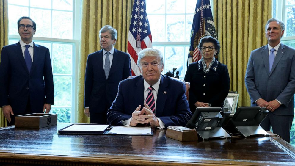 PHOTO:President Donald Trump is surrounded by administration officials and lawmakers prior to signing the "Paycheck Protection Program and Health Care Enhancement Act,"  at the White House in Washington, April 24, 2020. 