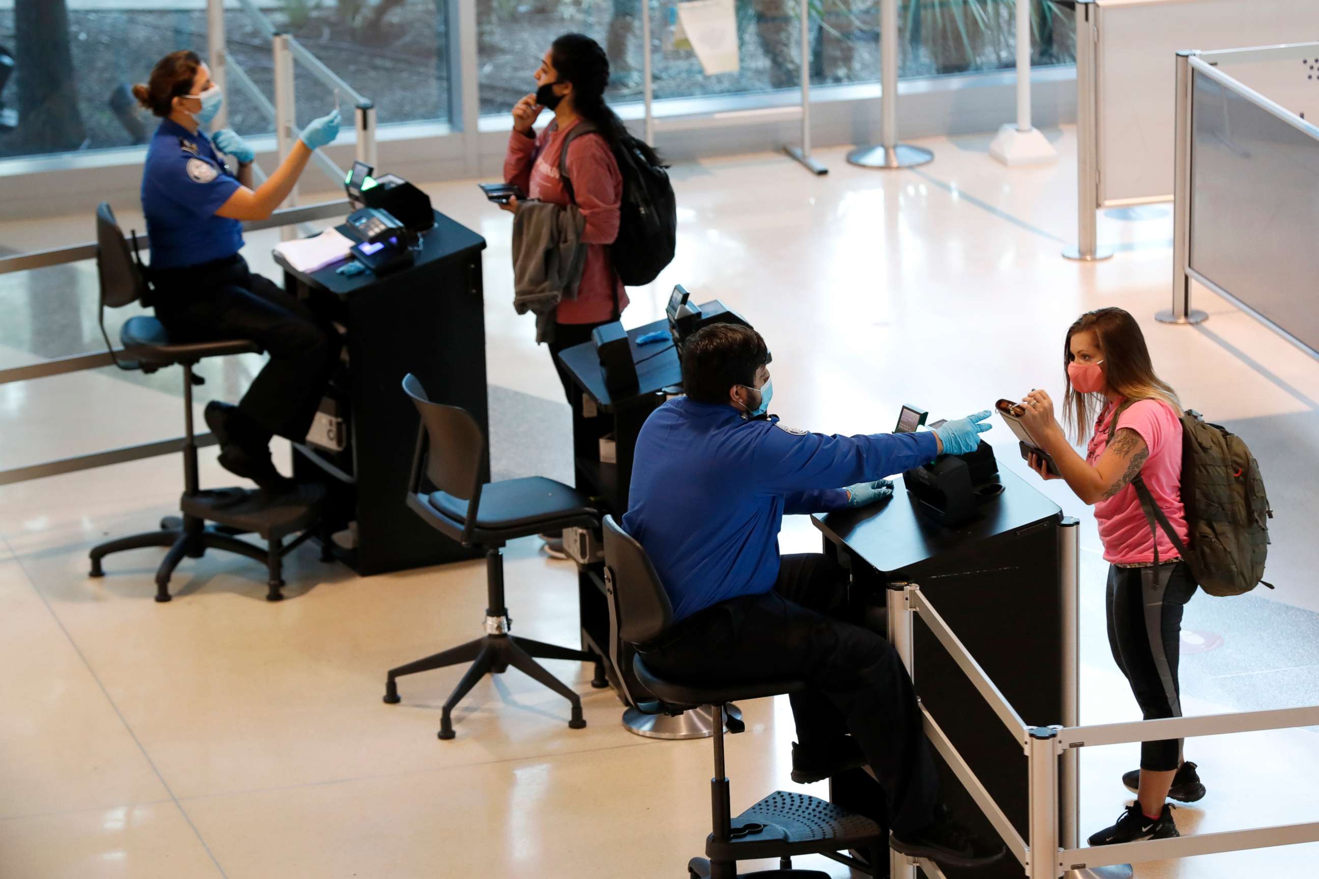 PHOTO: TSA agents help travelers as they clear security for flights out of Love Field in Dallas, June 24, 2020, file photo.