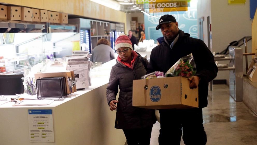 PHOTO: Nate Manning helps his friend and TSA worker Ebony Grays, carry a box of food she received at the Lakeview Pantry in Chicago, Jan. 14, 2019.