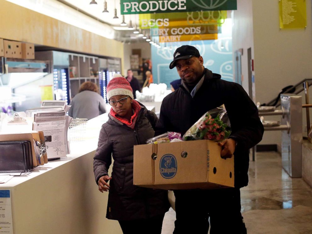 PHOTO: Nate Manning helps his friend and TSA worker Ebony Grays, carry a box of food she received at the Lakeview Pantry in Chicago, Jan. 14, 2019.