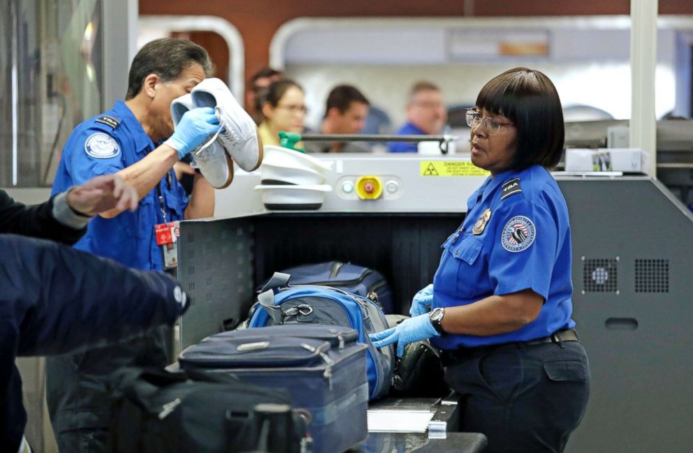 PHOTO: Transportation Security Administration (TSA) officers assist travelers with luggage through a security screening area during a partial federal government shutdown, Dec. 31, 2018, in SeaTac, Wash. 