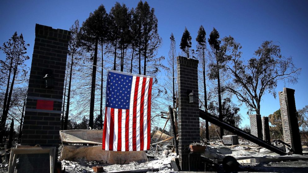 PHOTO: An American flag hangs in front of a home in the Coffey Park neighborhood that was destroyed by the Tubbs Fire, Oct. 23, 2017, in Santa Rosa, Calif.