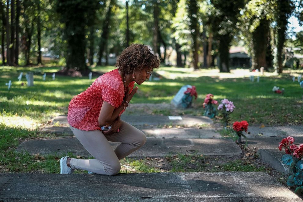 PHOTO: Brenda Tucker, a descendent of one of the first black Americans William Tucker, pays her respects at a family member's grave at the Tucker family cemetery in Hampton, Virginia, July 27, 2019.