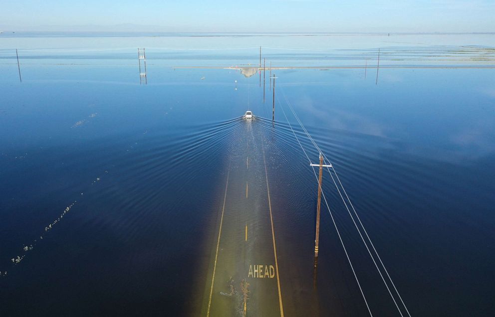 PHOTO: In an aerial view, a vehicle drives through floodwaters in the reemerging Tulare Lake, April 27, 2023, near Corcoran, Calif.
