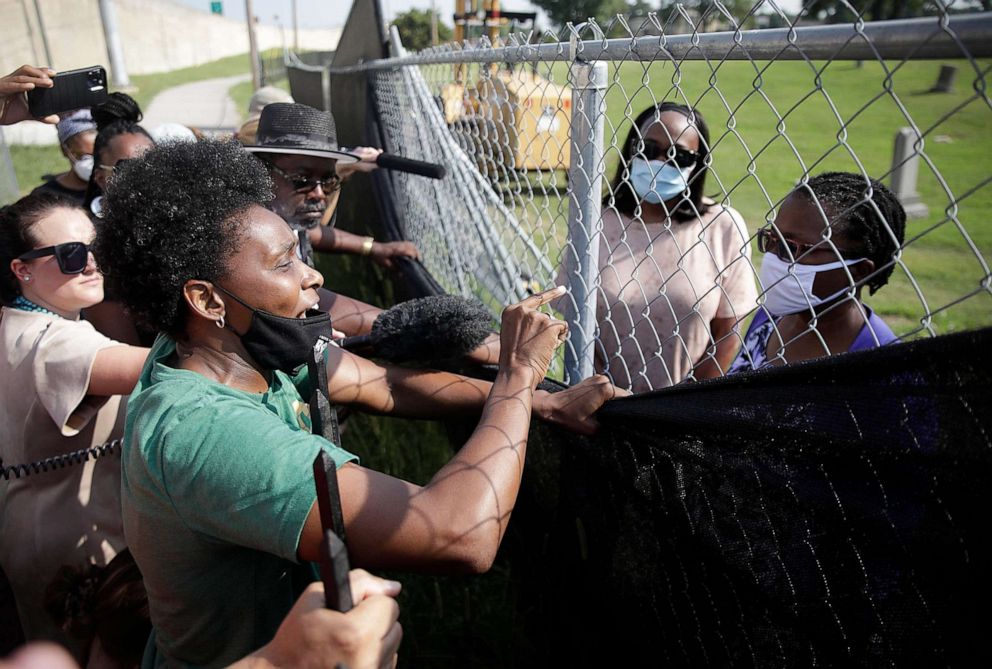 PHOTO: Tulsa Race Massacre descendant Heather Nash, left, yells at Brenda Alford, 1921 Graves Public Oversight Committee member Dr. Phoebe Stubblefield as remains from a mass grave are reintered at Oaklawn Cemetery in Tulsa, Okla., July 30, 2021.