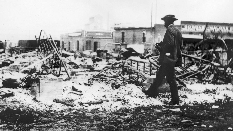 PHOTO: A man looks at the skeletons of iron beds which rise above the ashes of a burned-out block after the Tulsa Race Massacre in Tulsa, Okla., June 1921.