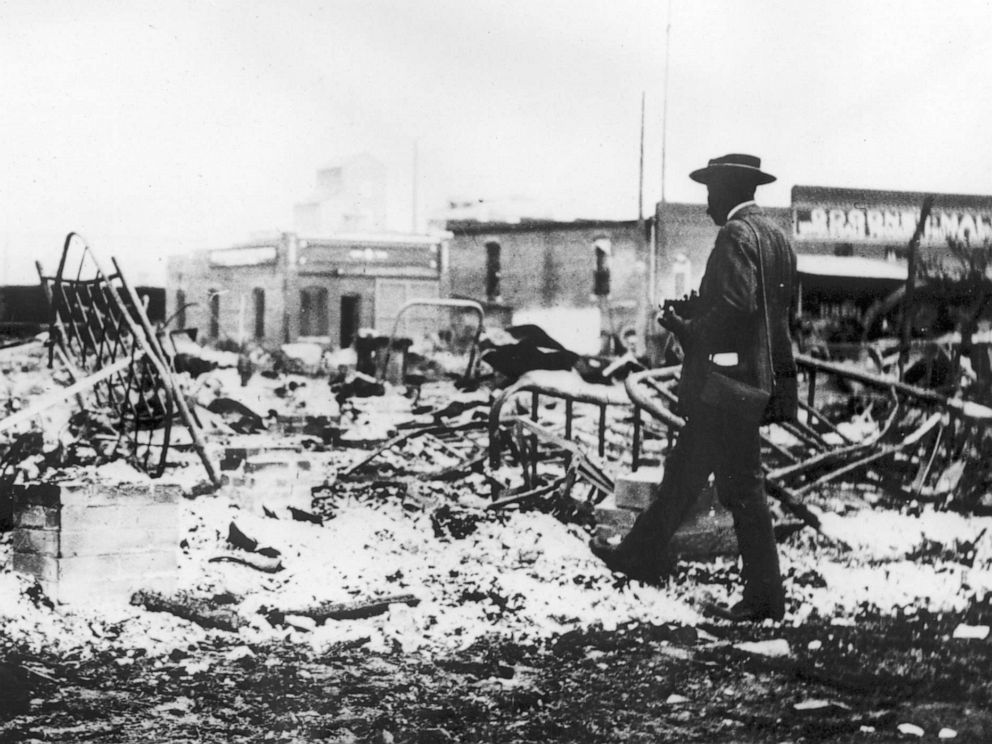 PHOTO: A man looks at the skeletons of iron beds which rise above the ashes of a burned-out block after the Tulsa Race Massacre in Tulsa, Okla., June 1921.