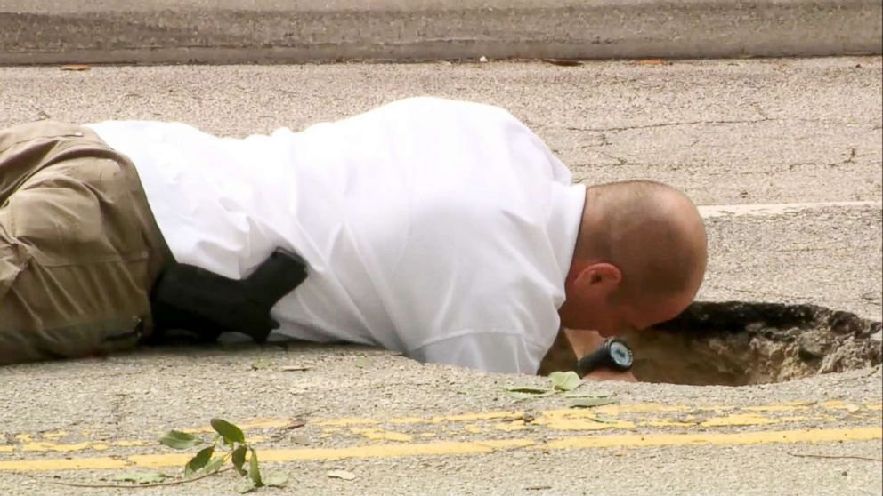 PHOTO: Authorities investigate a 50-yard tunnel leading from a wooded area to a Chase bank in Pembroke Pines, Fla.