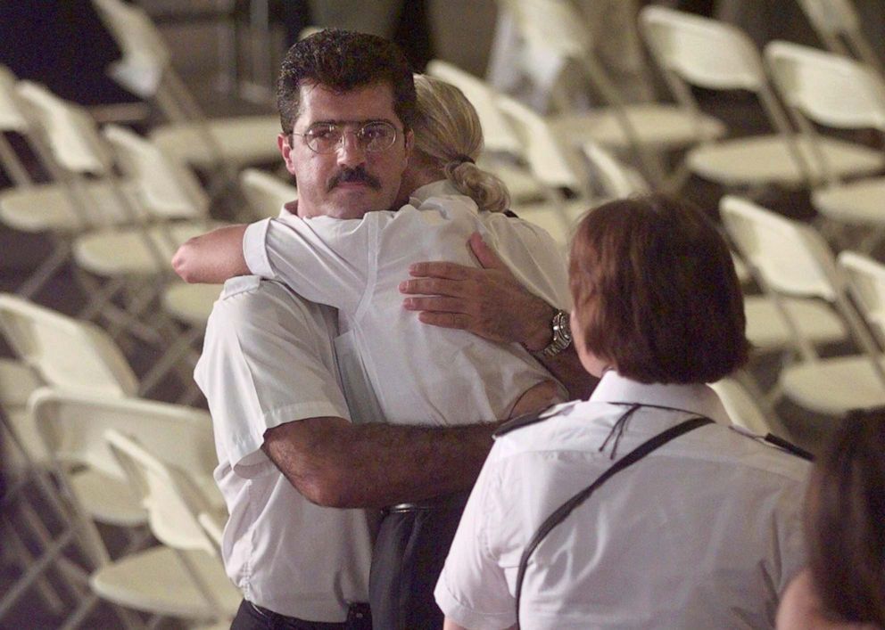 PHOTO: TWA employees embrace following a memorial service for victims of Flight 800 at Hangar 12 in New York's Kennedy Airport, July 16, 1997.