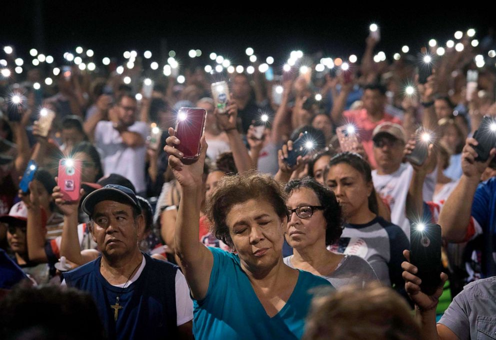 PHOTO: People hold up their phones during a prayer and candlelight vigil organized by the city of El Paso, after a shooting left 20 people dead at the Cielo Vista Mall Wal-Mart, Aug. 4, 2019.