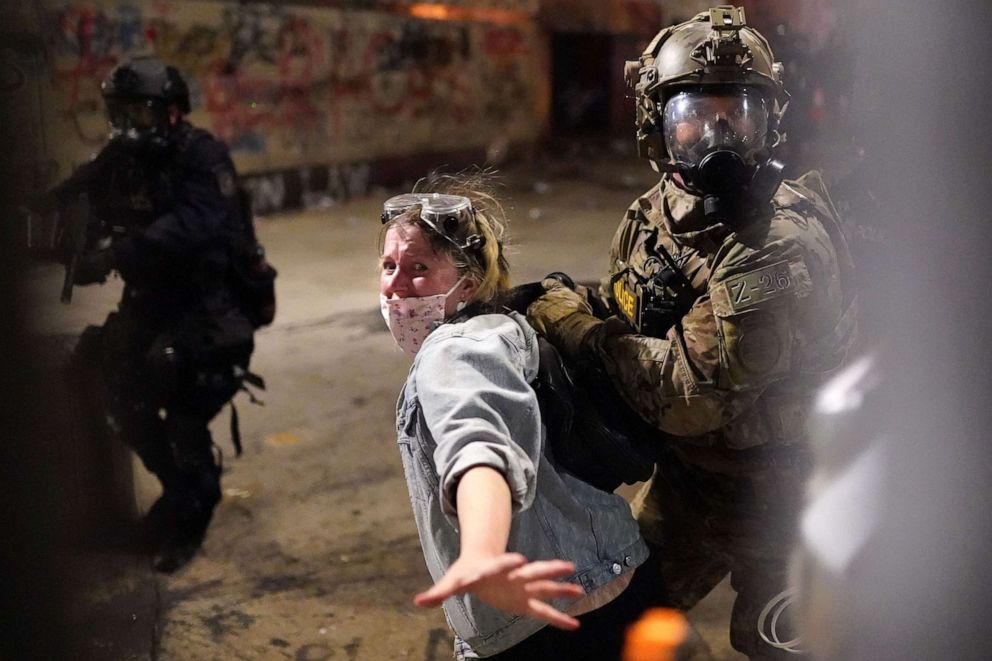 PHOTO: Federal officers arrest a protester after she crossed a fence line set up around the Mark O. Hatfield U.S. Courthouse, July 23, 2020, in Portland, Ore.