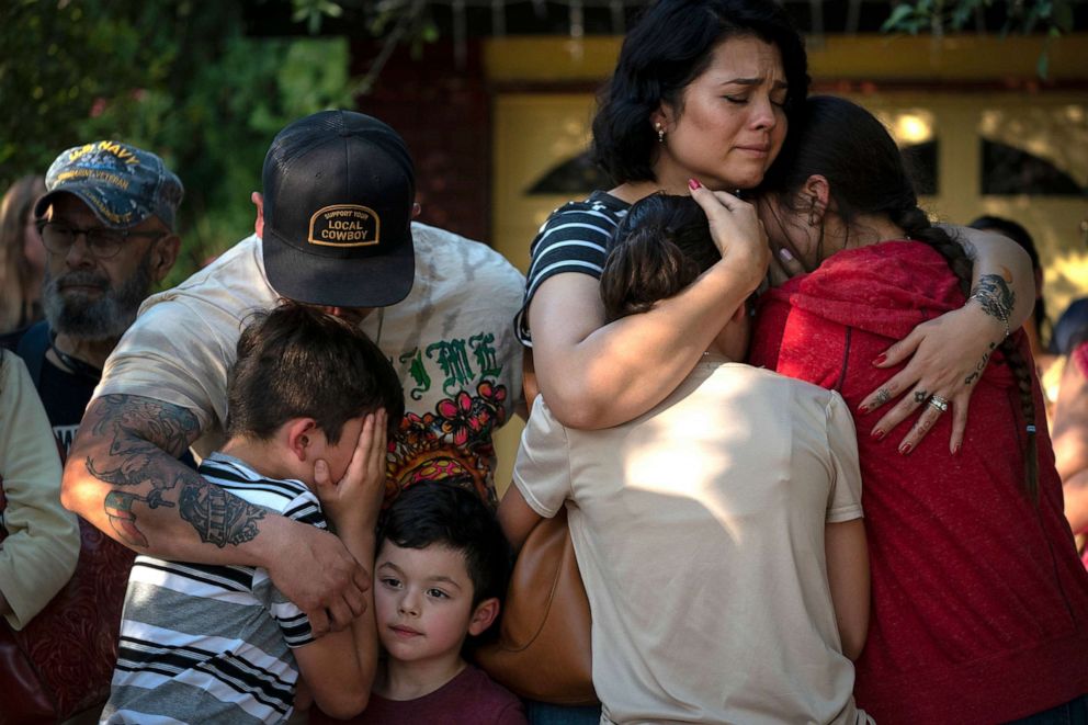 PHOTO: Raquel Martinez, comforts her two daughters while her husband, Daniel Martinez, comforts their sons outside Robb Elementary School, on May 26, 2022, in Uvalde, Texas. 