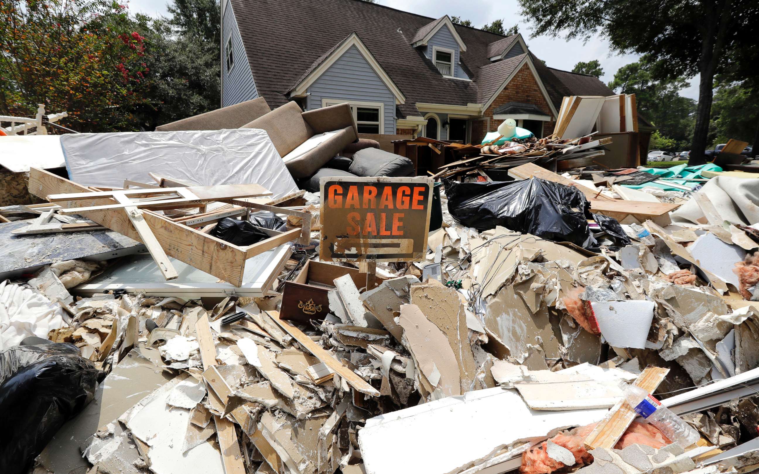 PHOTO: A garage sale sign stands in a pile of debris damaged by floodwaters in the aftermath of Hurricane Harvey in Spring, Texas, Sept. 3, 2017.