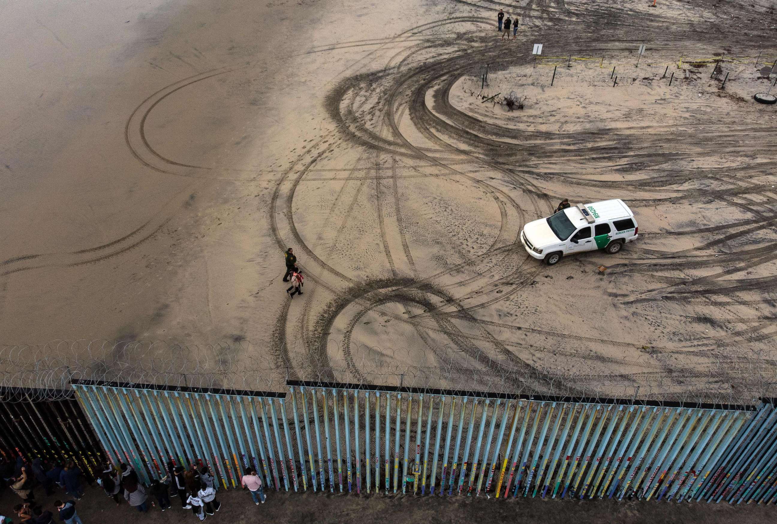 PHOTO: An aerial view of migrants who form part of the Central American migrant caravan being detained and escorted by a border patrol agent after crossing the U.S.-Mexico border fence in Playas de Tijuana, Baja California state, Mexico, Dec. 9, 2018.